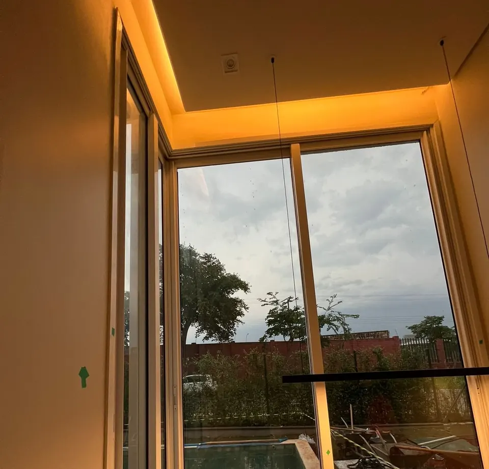 Janela acústica em canto de ambiente residencial, com iluminação embutida