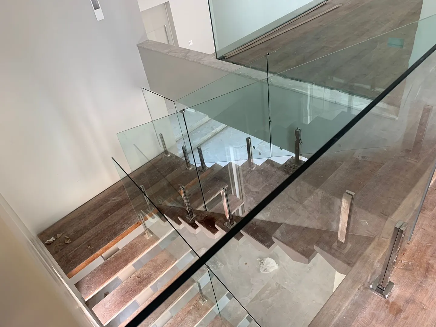 Guarda-corpo de vidro laminado instalado em escada, com fixação estrutural em alumínio