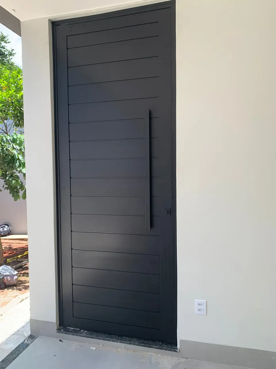 Porta pivotante de giro em lambri de alumínio preto, com perfil reduzido