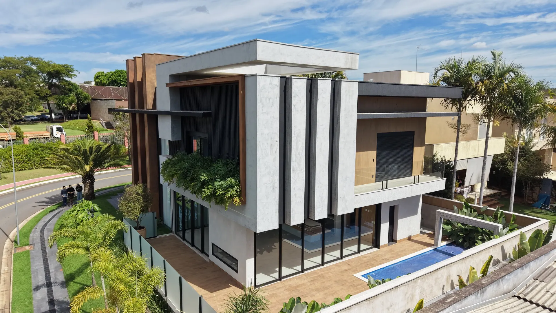 Casa Jardins Valência vista da rua, com a piscina e o paisagismo em primeiro plano